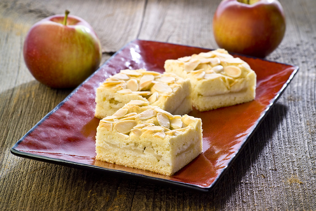 Almond topped cakes on red plate with apples